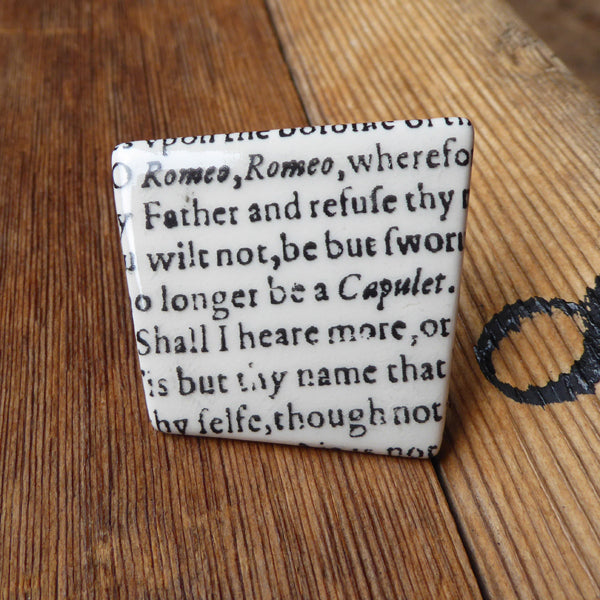 
                  
                    Asymmetric ceramic brooch with a snippet of Juliet's balcony speech from Shakespeare's Romeo and Juliet
                  
                