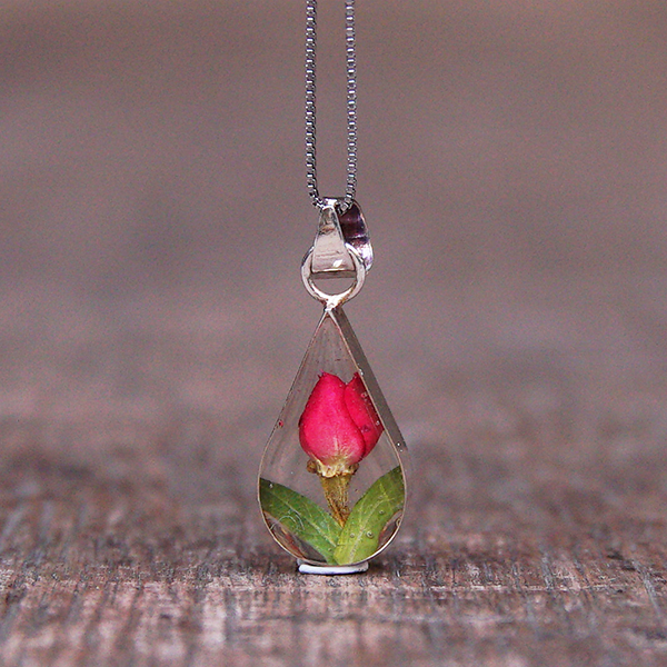 Tiny real rose encased in resin on a silver chain