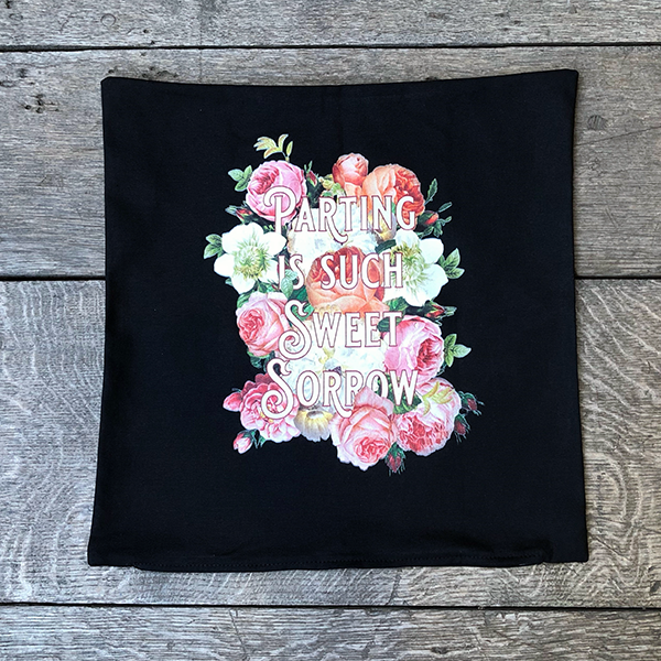 Square black cotton cushion cover with an image celebrating Shakespeare play, Romeo & Juliet. A photographic background of cream, pink and peach roses, with a quote from the play, "parting is such sweet sorrow" in light pink fancy letters.