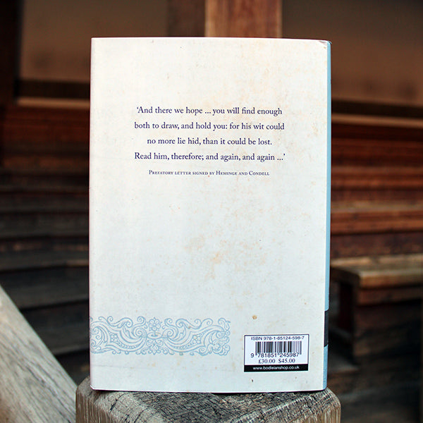 Hardback book with white jacket sleeve, with lines of text in centre back.