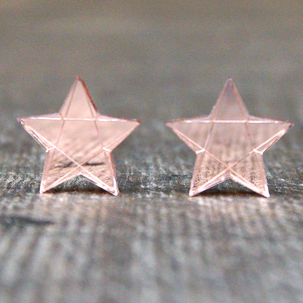 
                  
                    Star shaped stud earrings made from rose gold coloured mirrored acrylic. The stars are engraved to look faceted
                  
                