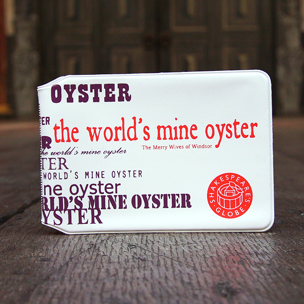 White PVC travel wallet printed with a quote from Shakespeare play, The Merry Wives of Windsor (The world's mine oyster). The quote is printed multiple times, each time in a different font in purple. The central print of the quote is in orange an looks as though it has been printed on an old fashioned printing press.